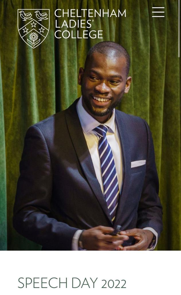 Man in a suit smiling during Cheltenham Ladies' College Speech Day 2022. Green curtain backdrop, logo and event title visible.